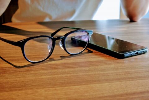 テーブルの上の眼鏡とスマホ